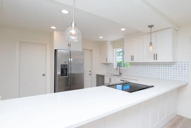 a kitchen with kitchen island a sink stainless steel appliances and refrigerator