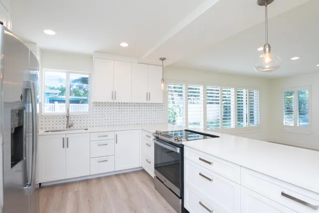 a kitchen with granite countertop white cabinets and white appliances