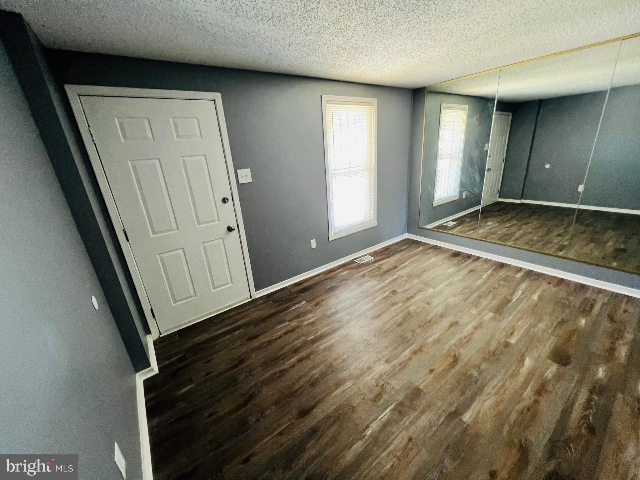 1808 North Spring Street Baltimore, MD 21213 - Photo 5 of 24 an empty room with wooden floor and windows