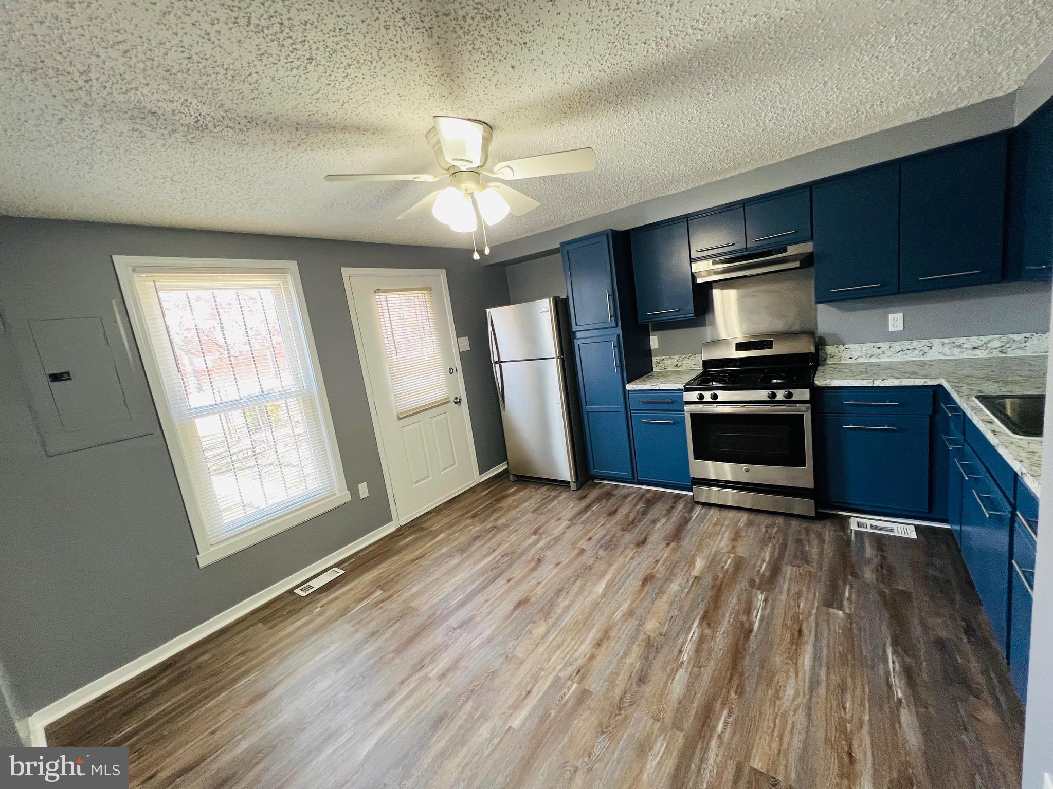 1808 North Spring Street Baltimore, MD 21213 - Photo 10 of 24 a kitchen with granite countertop stainless steel appliances a stove cabinets and refrigerator