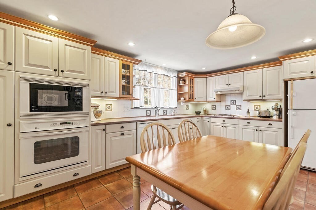 6 Lantern Lane Winchester, MA 01890 - Photo 17 of 40 a kitchen with kitchen island granite countertop wooden cabinets and a stove