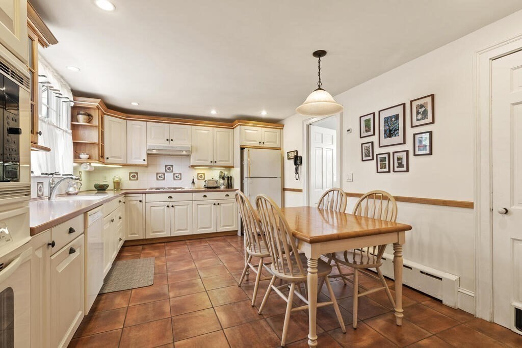 6 Lantern Lane Winchester, MA 01890 - Photo 18 of 40 a kitchen with stainless steel appliances granite countertop a dining table chairs stove and white cabinets