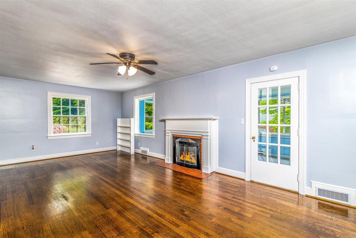 3223 Lawndale Road Roanoke, VA 24018 - Photo 5 of 37 an empty room with windows fireplace and wooden floor