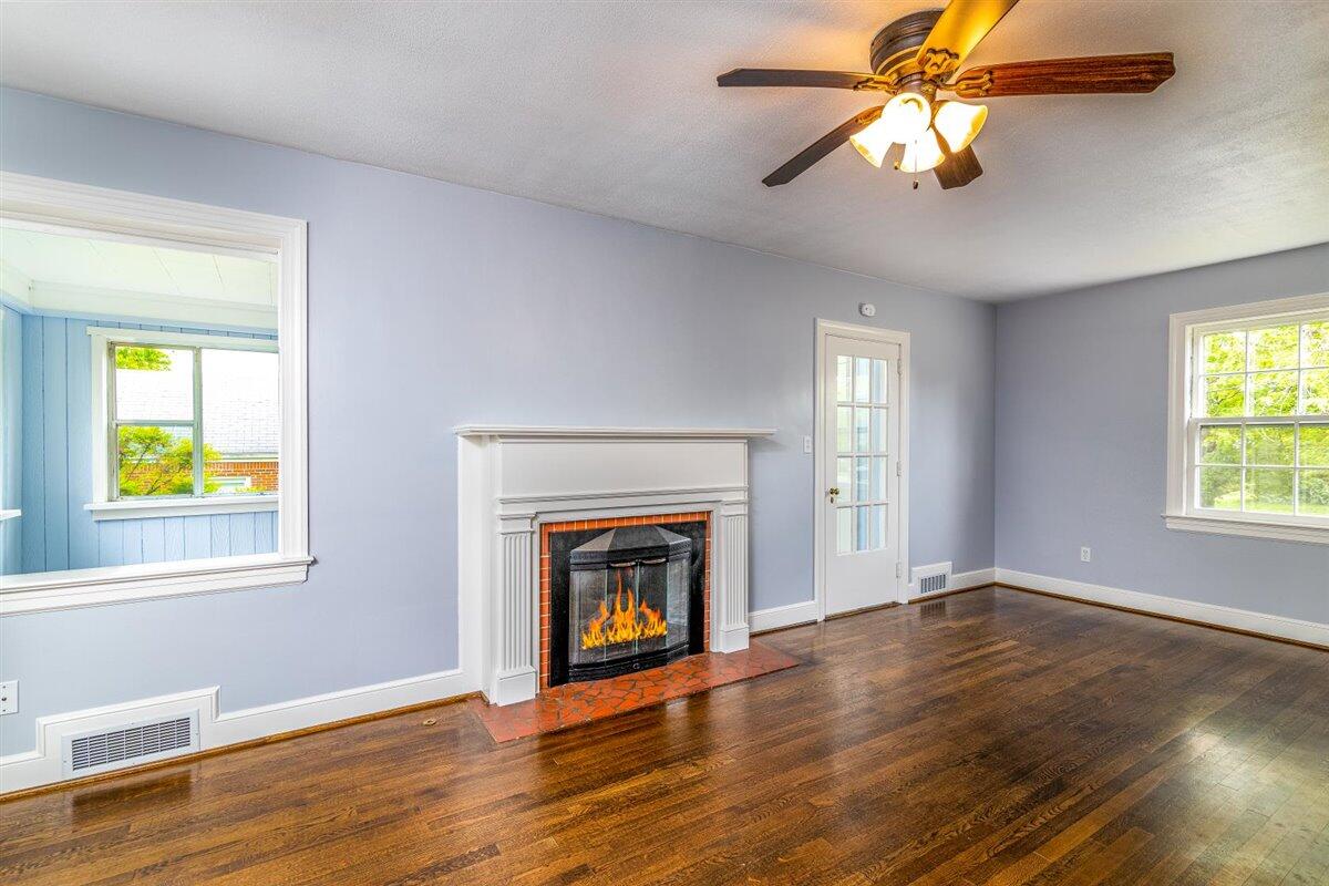 3223 Lawndale Road Roanoke, VA 24018 - Photo 7 of 37 an empty room with windows fireplace and wooden floor