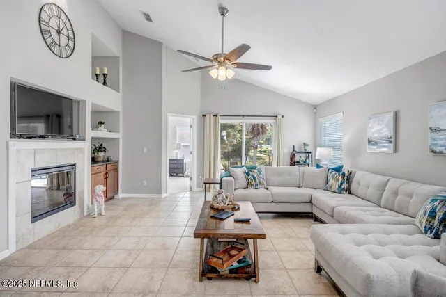 a living room with furniture a flat screen tv and a fireplace