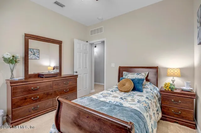 a bedroom with a bed and a mirror on dresser