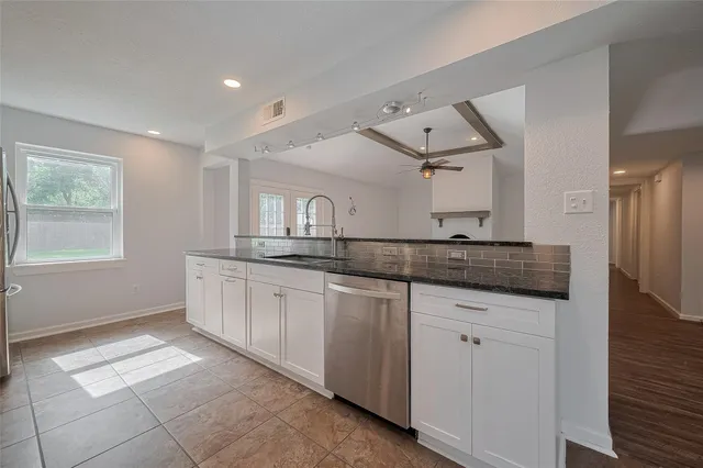 a spacious bathroom with a granite countertop sink and a mirror