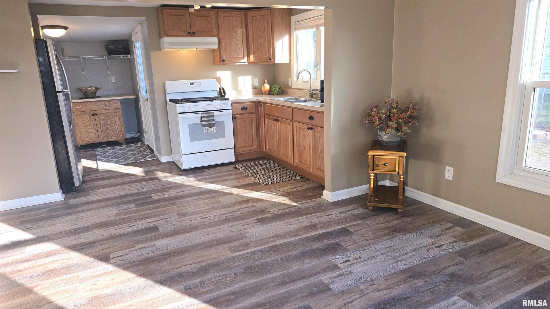 1006 8th Street Colona, IL 61241 - Photo 2 of 16 a kitchen with granite countertop a stove a sink and a refrigerator