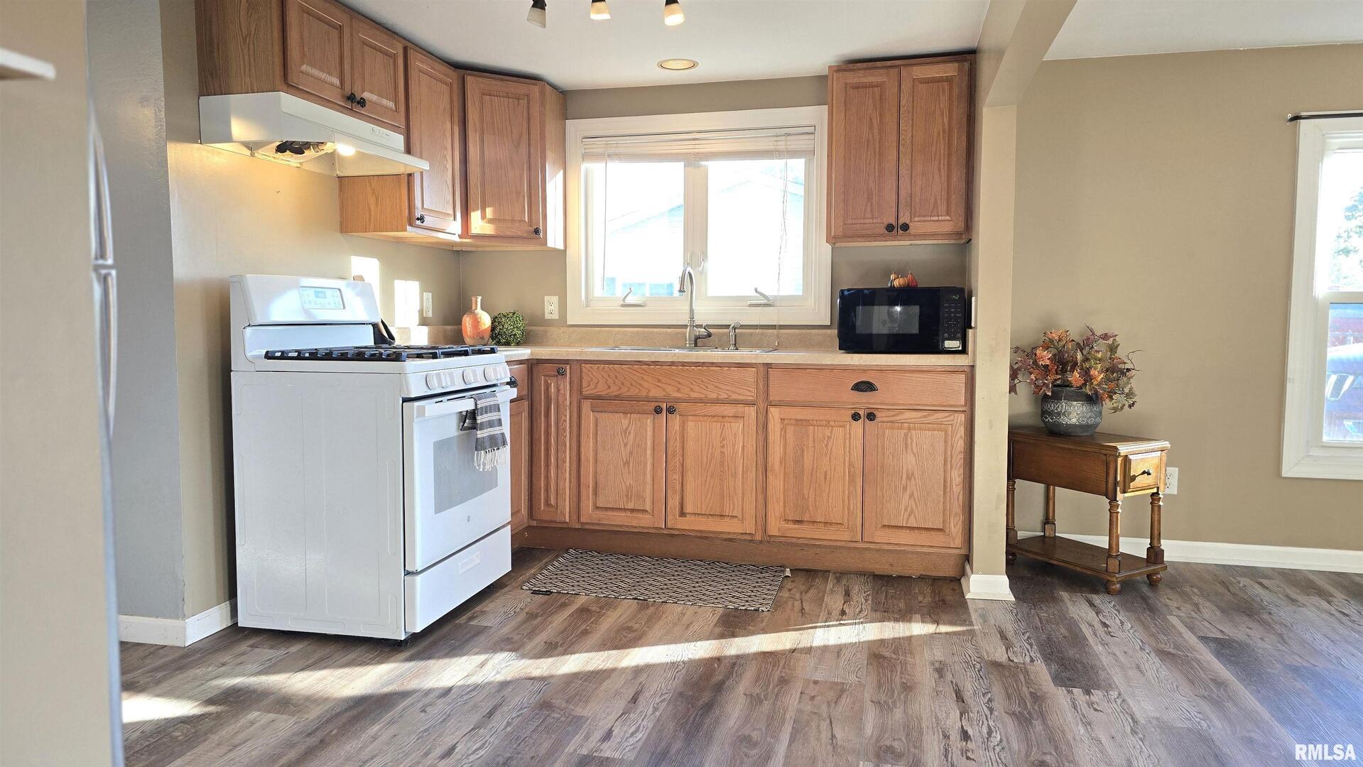 1006 8th Street Colona, IL 61241 - Photo 5 of 16 a kitchen with stainless steel appliances granite countertop a stove a sink and white cabinets