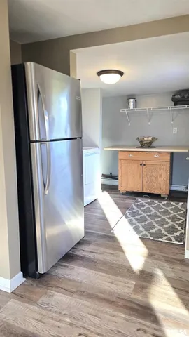 a view of a refrigerator in kitchen and wooden floor