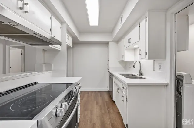 a kitchen with a sink stove top oven and cabinets