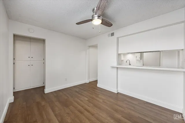 a view of an empty room with wooden floor