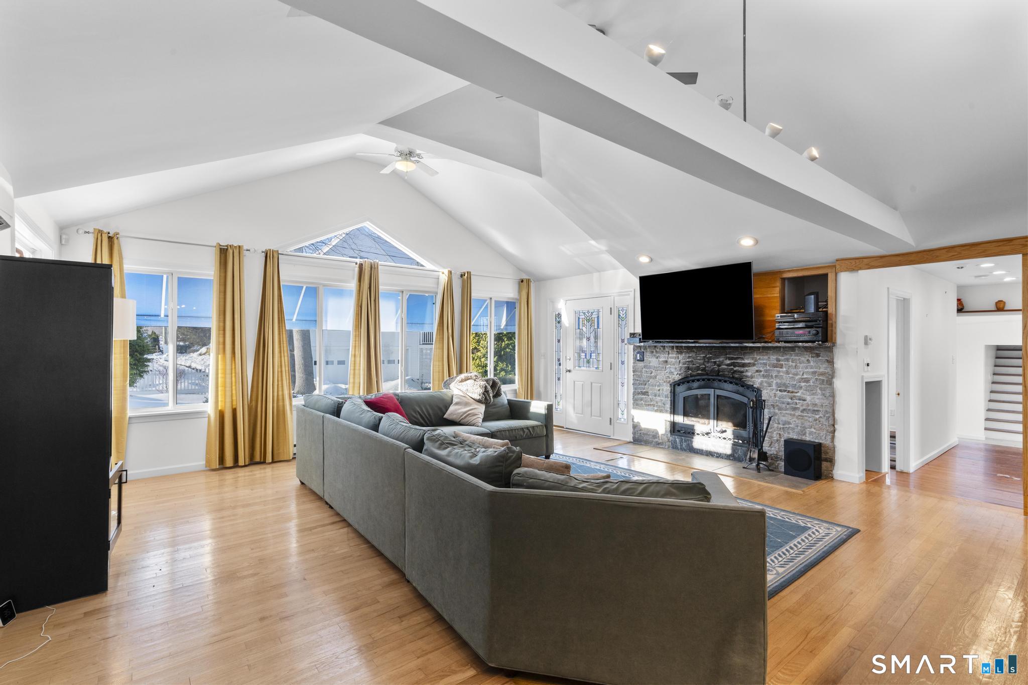 231 Pawson Road Branford, CT 06405 - Photo 6 of 17 a living room with fireplace furniture and a flat screen tv