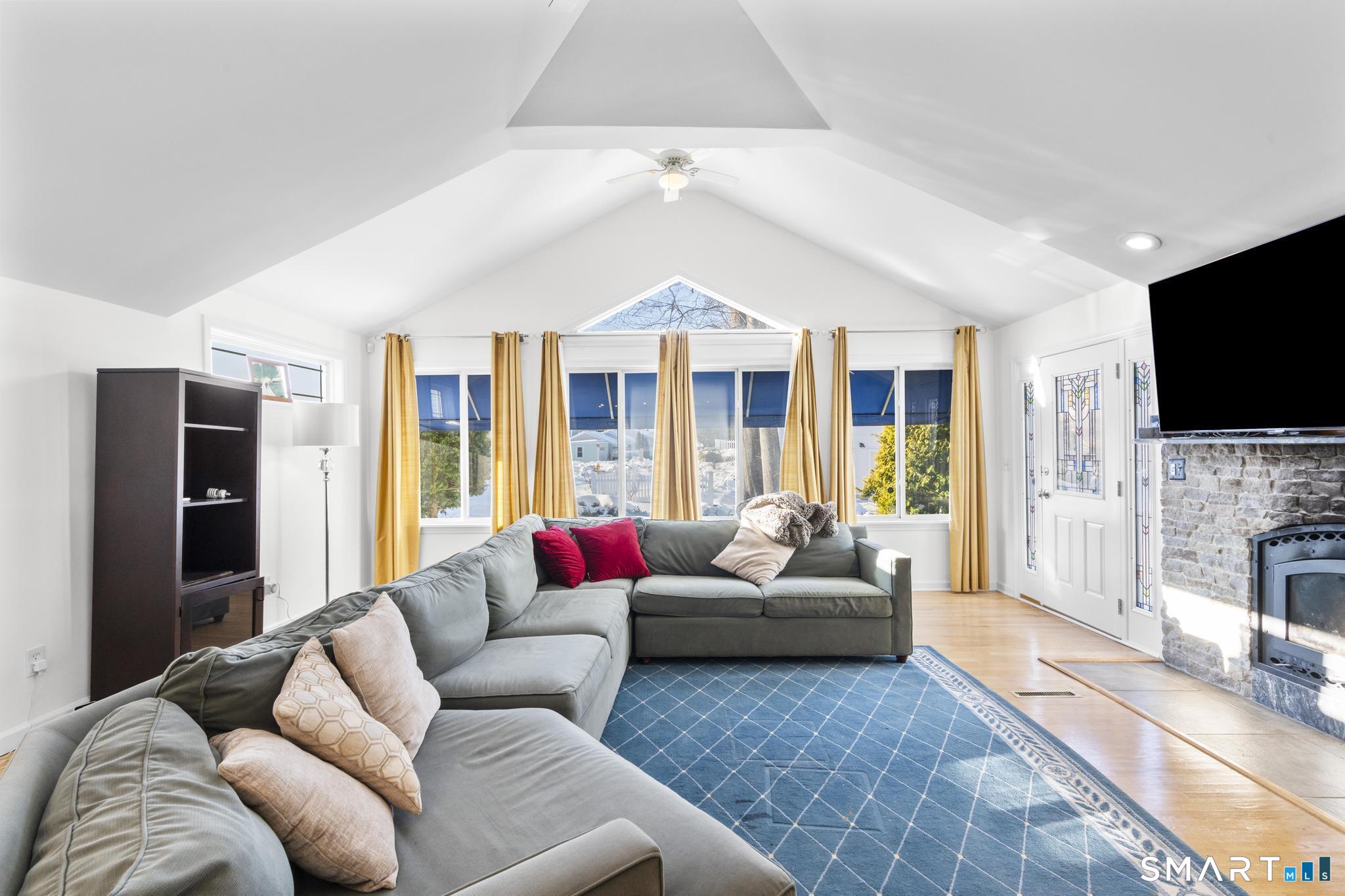 231 Pawson Road Branford, CT 06405 - Photo 7 of 17 a living room with furniture a flat screen tv and a fireplace