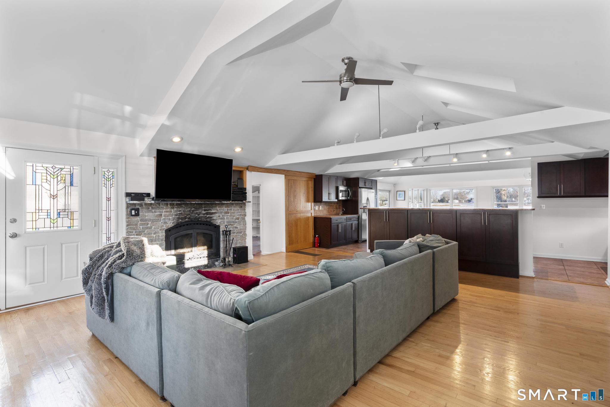 231 Pawson Road Branford, CT 06405 - Photo 8 of 17 a living room with fireplace furniture and a flat screen tv