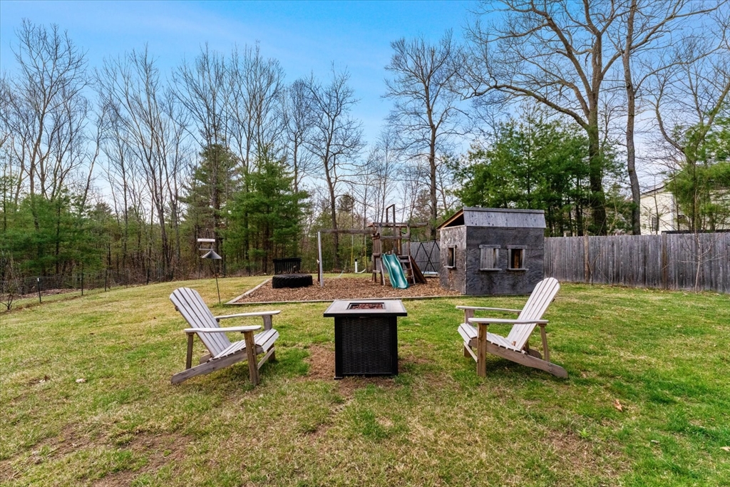50 Quabbin Path Sutton, MA 01590 - Photo 36 of 42 a view of a backyard with chairs potted plants and a large tree