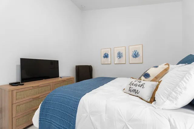 a bedroom with a bed and a flat screen tv