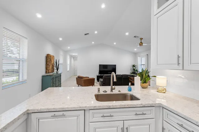 a kitchen with sink and mirror