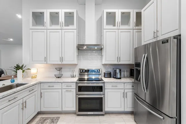a kitchen with stainless steel appliances granite countertop a refrigerator sink and cabinets
