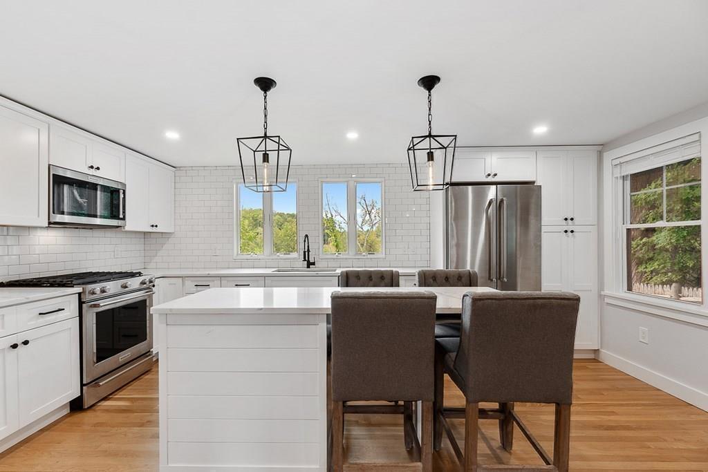 68 Still River Road Harvard, MA 01451 - Photo 17 of 40 a kitchen with kitchen island granite countertop a stove a sink a dining table and chairs