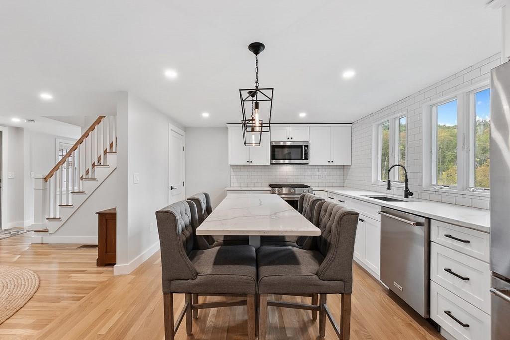 68 Still River Road Harvard, MA 01451 - Photo 19 of 40 a kitchen with stainless steel appliances granite countertop a dining table chairs sink and cabinets