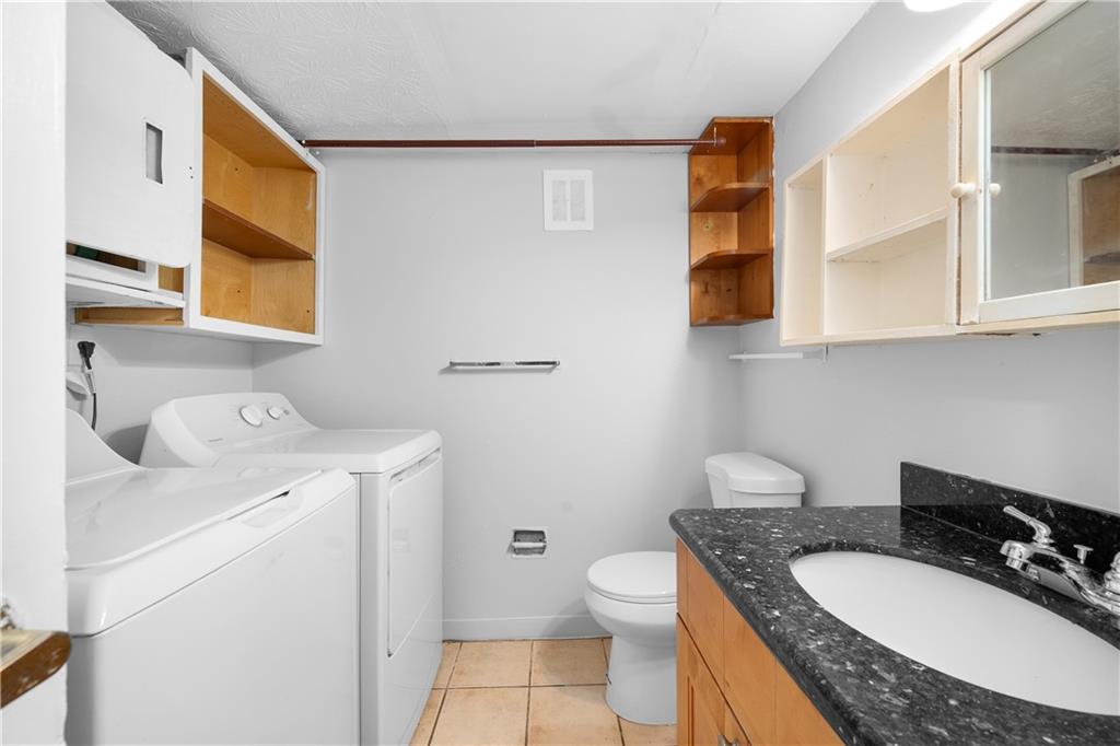 2956 North Dekalb Drive, Unit C Atlanta, GA 30340 - Photo 12 of 25 a bathroom with a granite countertop sink a mirror and a toilet