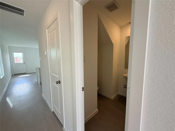 a view of a hallway with wooden floor