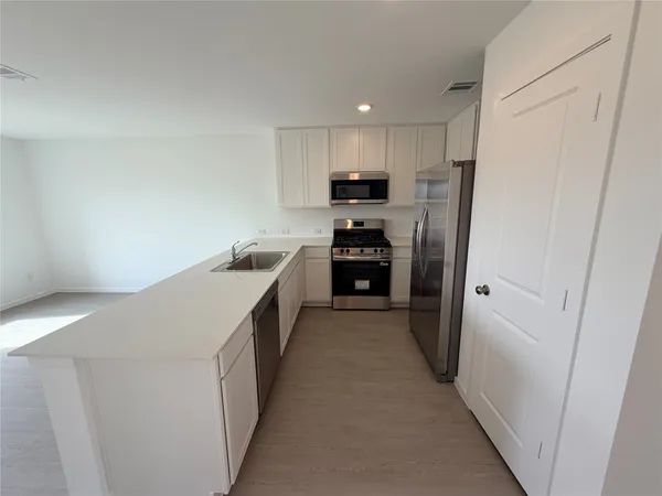 a kitchen with stainless steel appliances a refrigerator and a sink