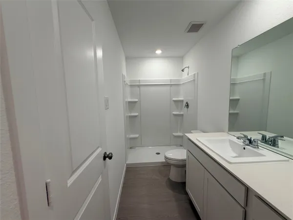 a bathroom with a sink a toilet and shower