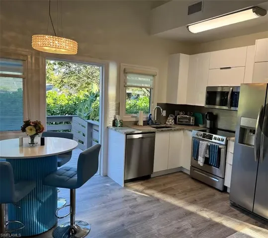 a kitchen with kitchen island granite countertop a sink cabinets and stainless steel appliances