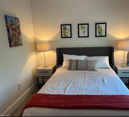 a bedroom with a bed and painting on the wall