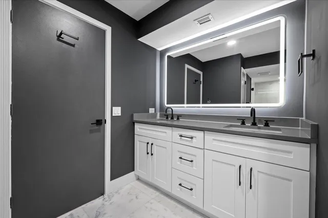 a bathroom with a sink and two mirror