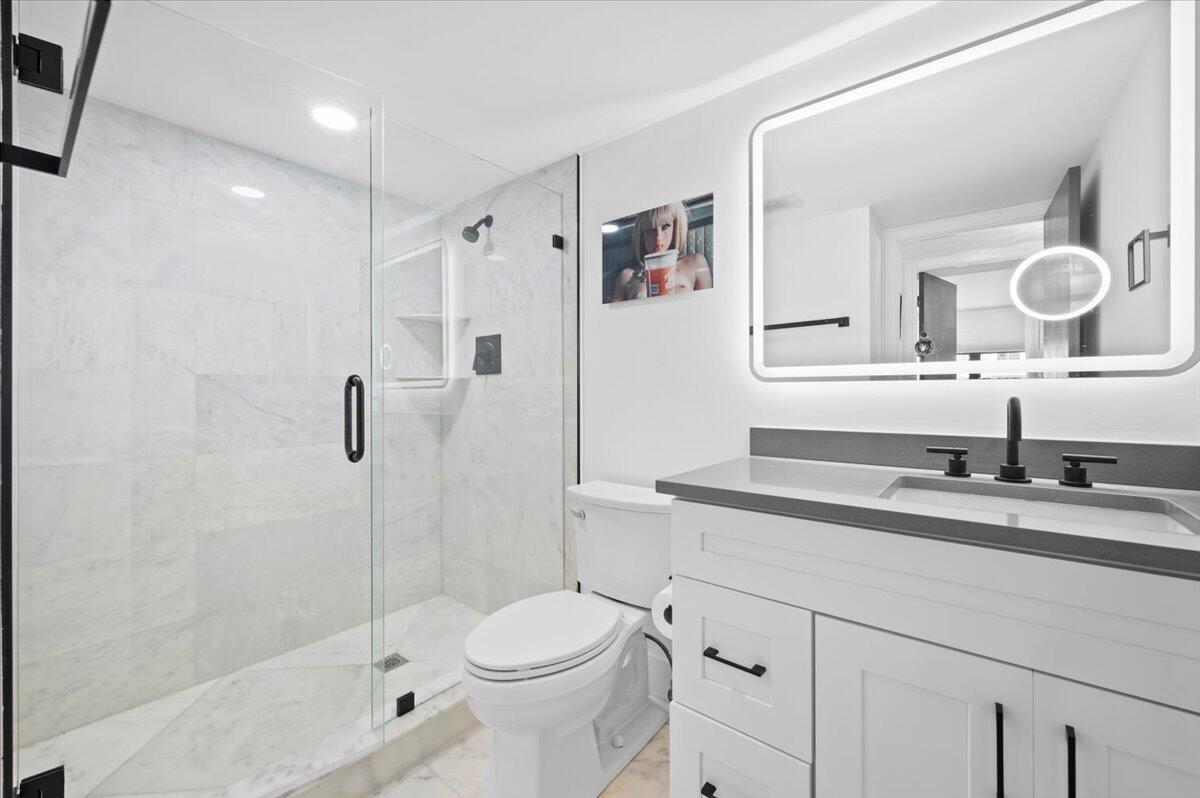 3400 North Ocean Drive, Unit 1806 Singer Island, FL 33404 - Photo 15 of 55 a bathroom with a granite countertop sink toilet mirror and shower
