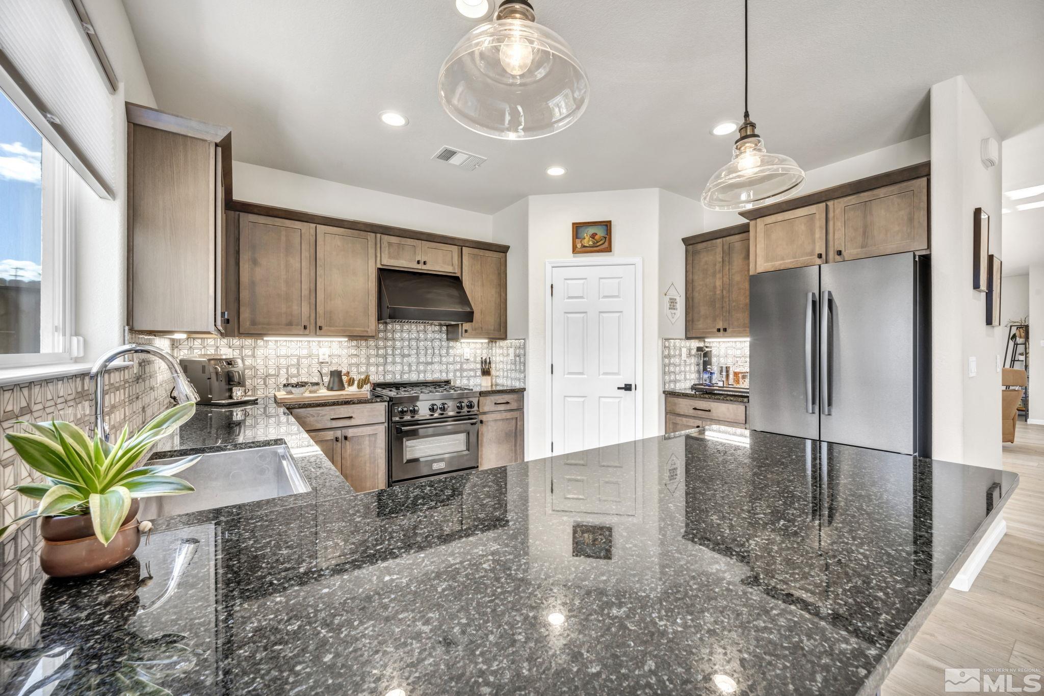 1433 Washington Street Reno, NV 89503 - Photo 18 of 35 a kitchen with stainless steel appliances granite countertop a refrigerator a stove a sink a dining table and chairs with wooden floor