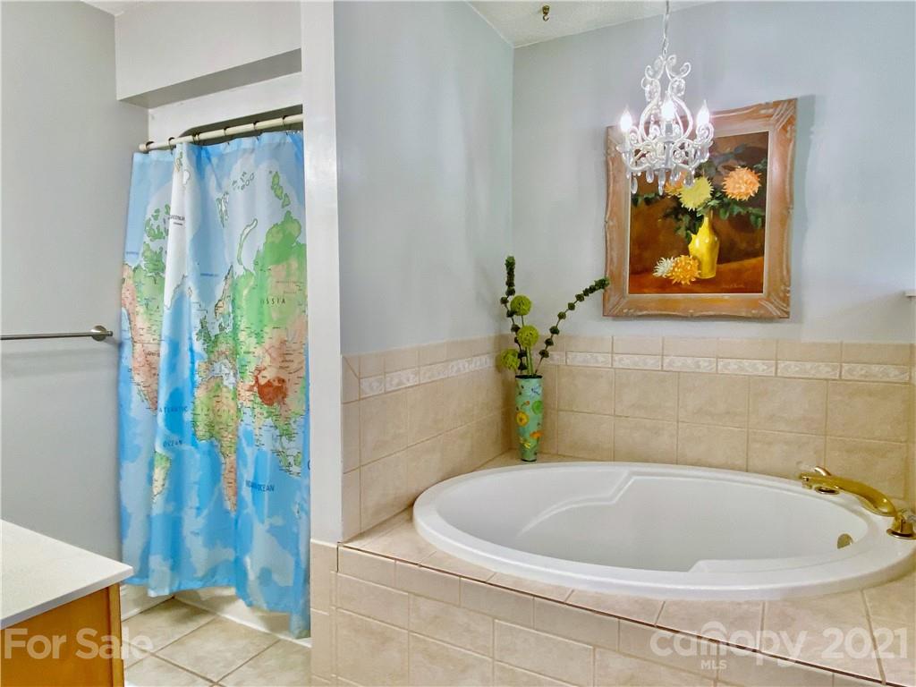 2280 Gheen Road Salisbury, NC 28147 - Photo 24 of 39 a white bath tub sitting next to a blue sink and painted walls