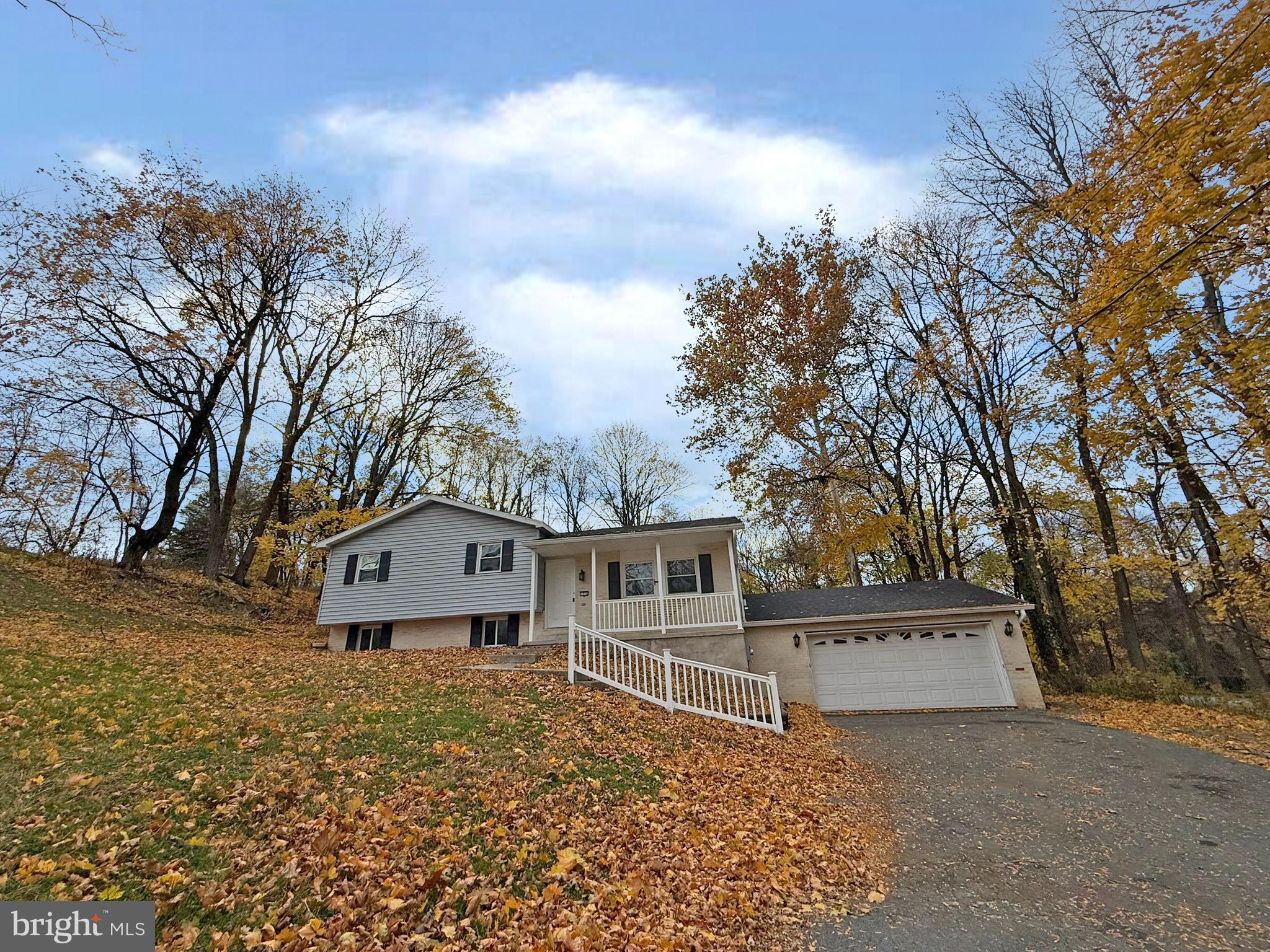 a view of a house with a large tree and wooden fence