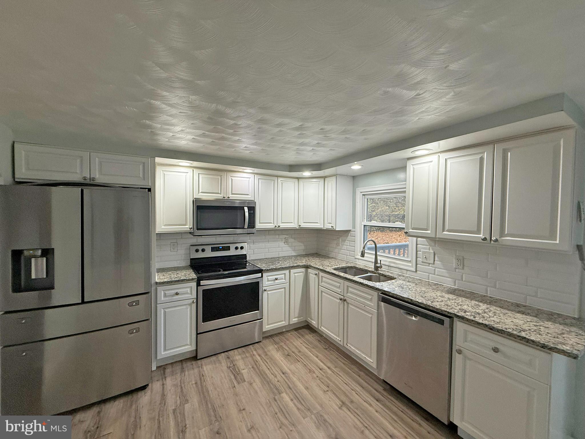 1316 Edgemont Road Harrisburg, PA 17109 - Photo 4 of 21 a kitchen with stainless steel appliances granite countertop a stove a sink and a refrigerator