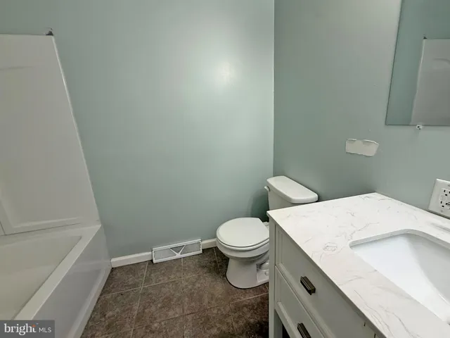 a white toilet sitting next to a bath tub
