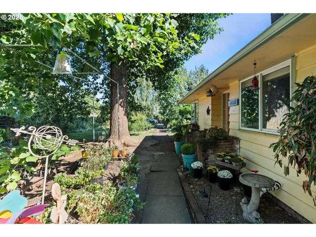 a view of a patio with table and chairs potted plants and large tree
