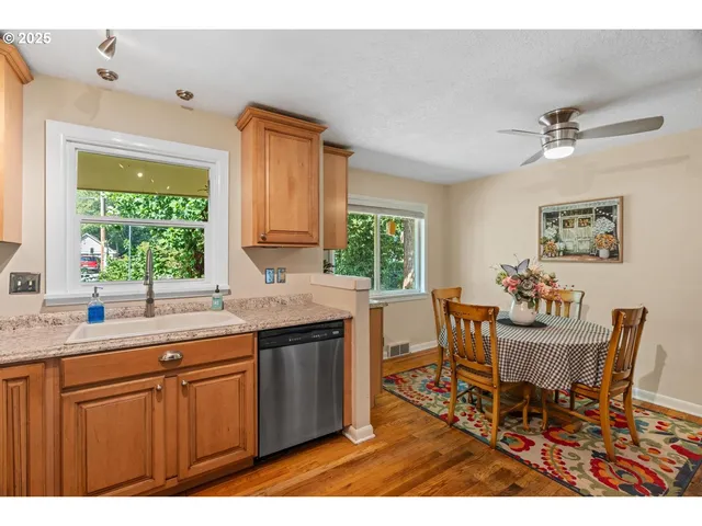 a kitchen with granite countertop a sink dining table and chairs