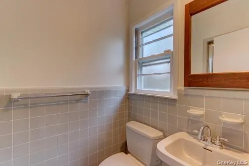a bathroom with a toilet sink and mirror