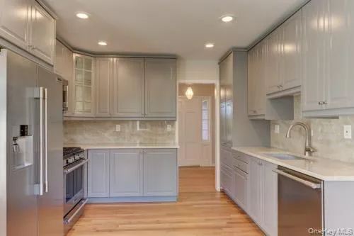 a kitchen with stainless steel appliances granite countertop a refrigerator and a sink