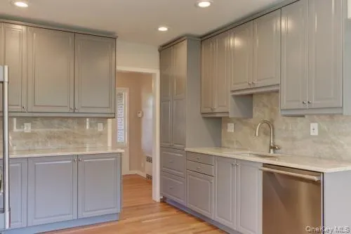 a kitchen with stainless steel appliances granite countertop white cabinets and sink
