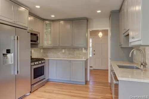 a kitchen with stainless steel appliances granite countertop a refrigerator and a sink