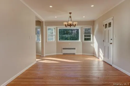an empty room with wooden floor and a window