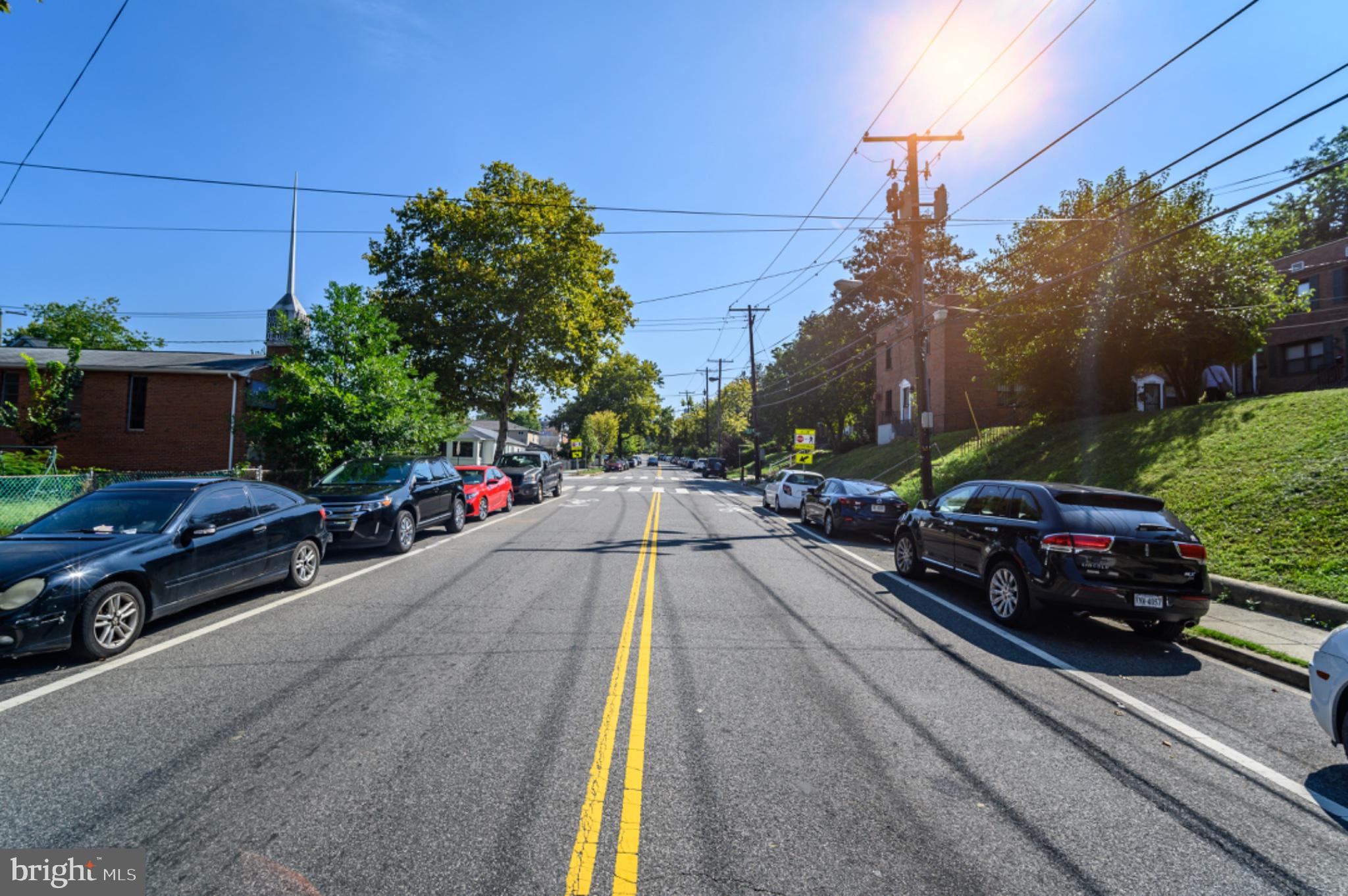 5053 Sheriff Road Northeast Washington, DC 20019 - Photo 22 of 32 Sunny street lined with parked cars.