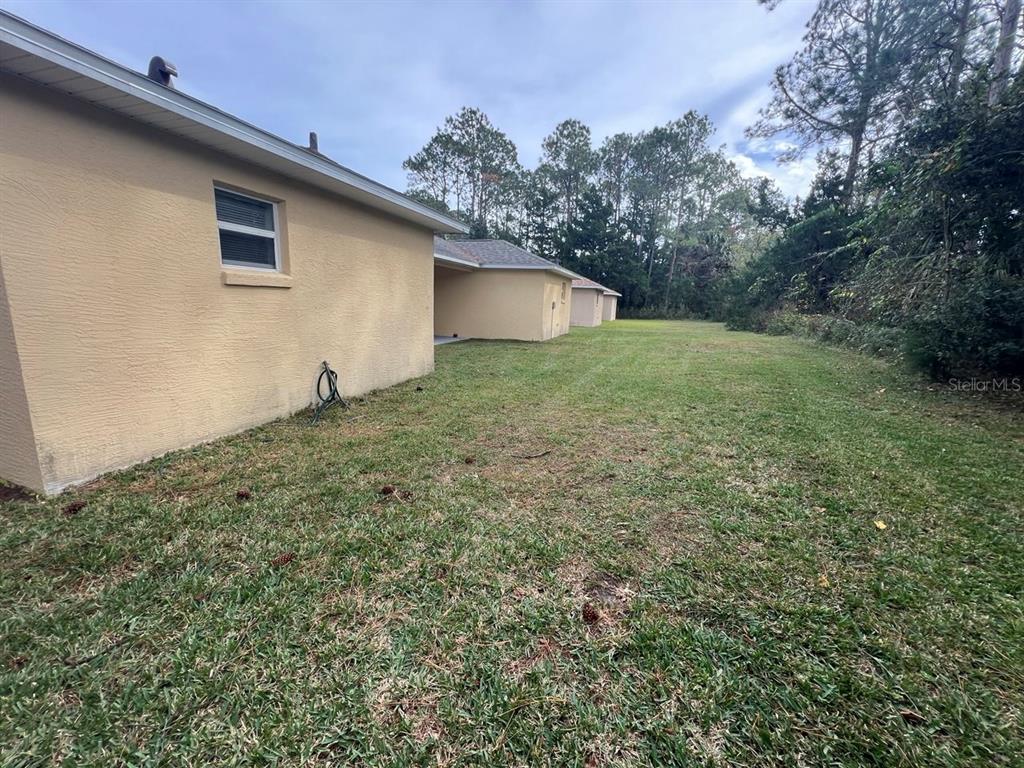 15 Bunker Knolls Lane, Unit B Palm Coast, FL 32137 - Photo 11 of 11 a view of a backyard with large trees