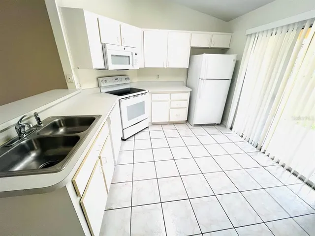 a kitchen with a sink a stove a refrigerator and cabinets