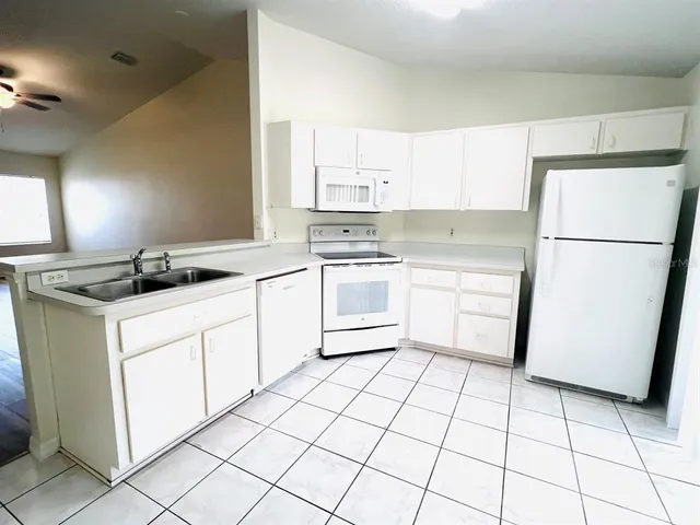 a kitchen with a sink a stove a refrigerator and cabinets