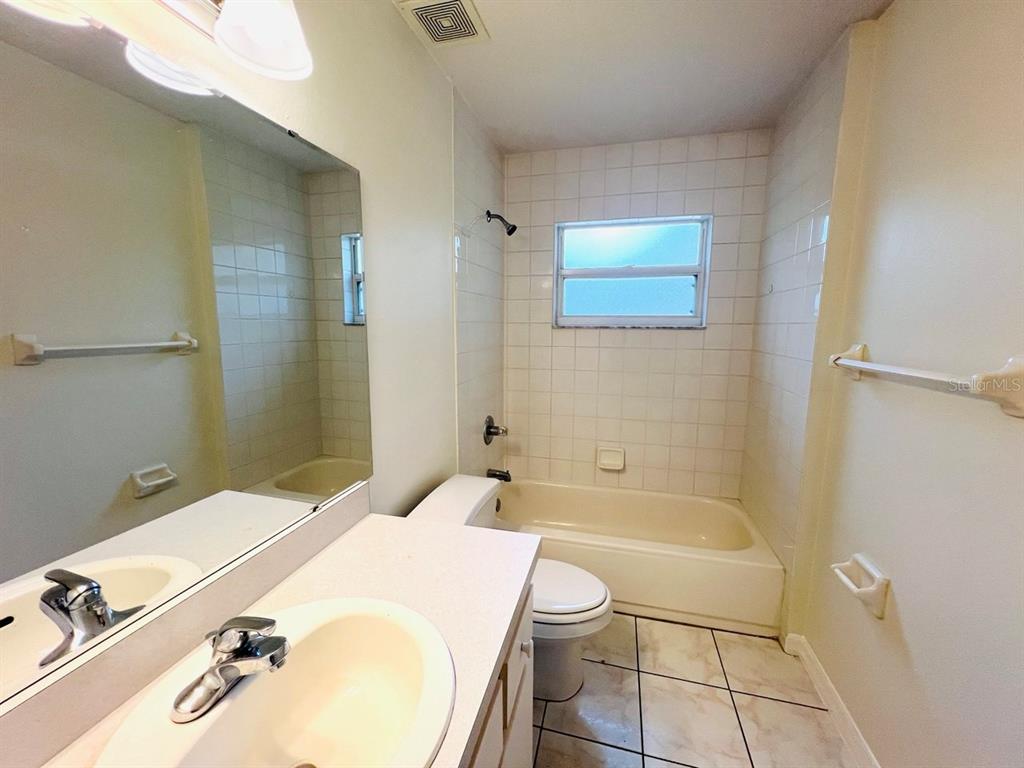 15 Bunker Knolls Lane, Unit B Palm Coast, FL 32137 - Photo 8 of 11 a bathroom with a tub sink and mirror